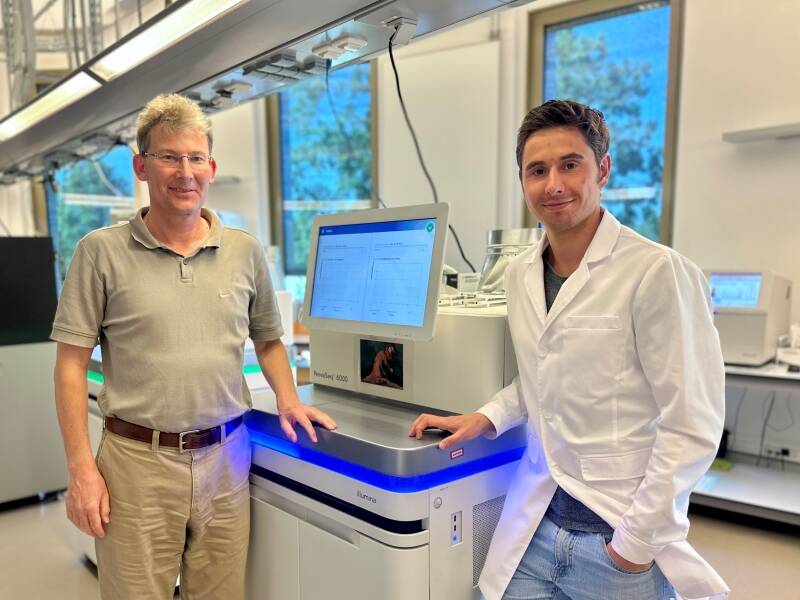 Dr. Michael Forster, Leiter der Arbeitsgruppe Liquid Biomarkers, Letztautor, und Tim Steiert, Erstautor des Artikels, (v. l.) vor einem modernen Sequenzierer des IKMB zur molekulargenetischen Untersuchung von Krebsproben.